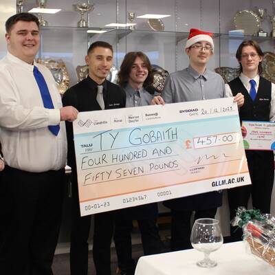 Coleg Llandrillo students holding a cheque for Tŷ Gobaith after a fund-raising meal was held at the Orme View restaurant