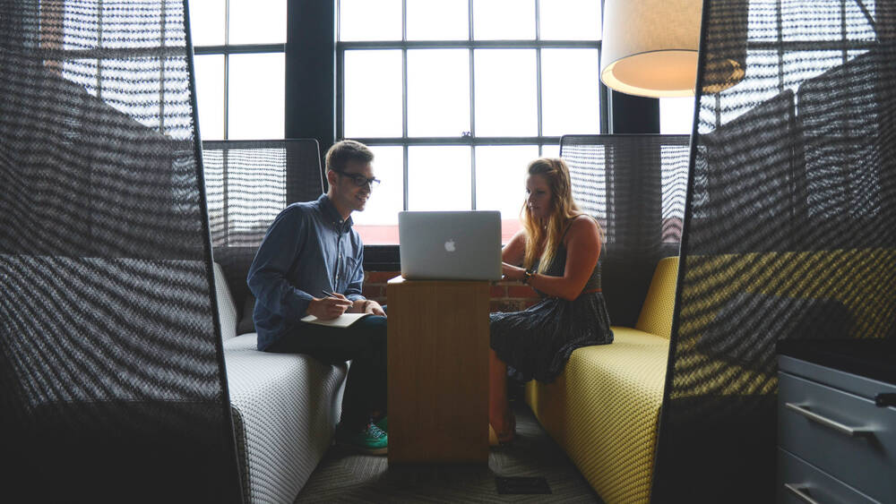 Two people using a laptop