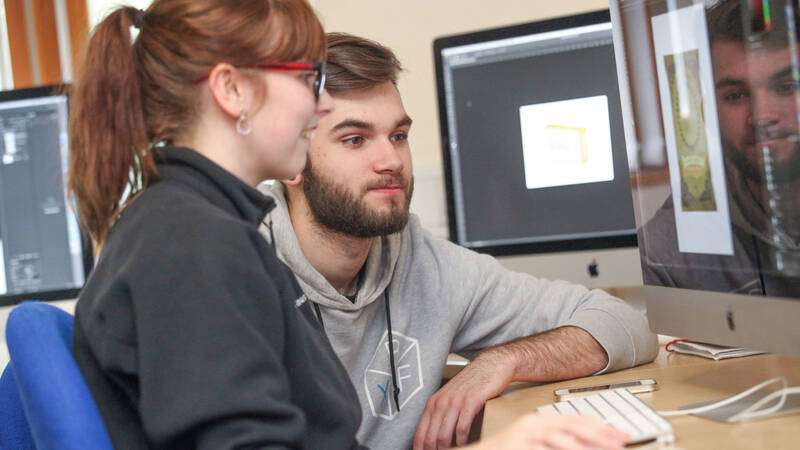 Female and Male learner working on an Apple iMac