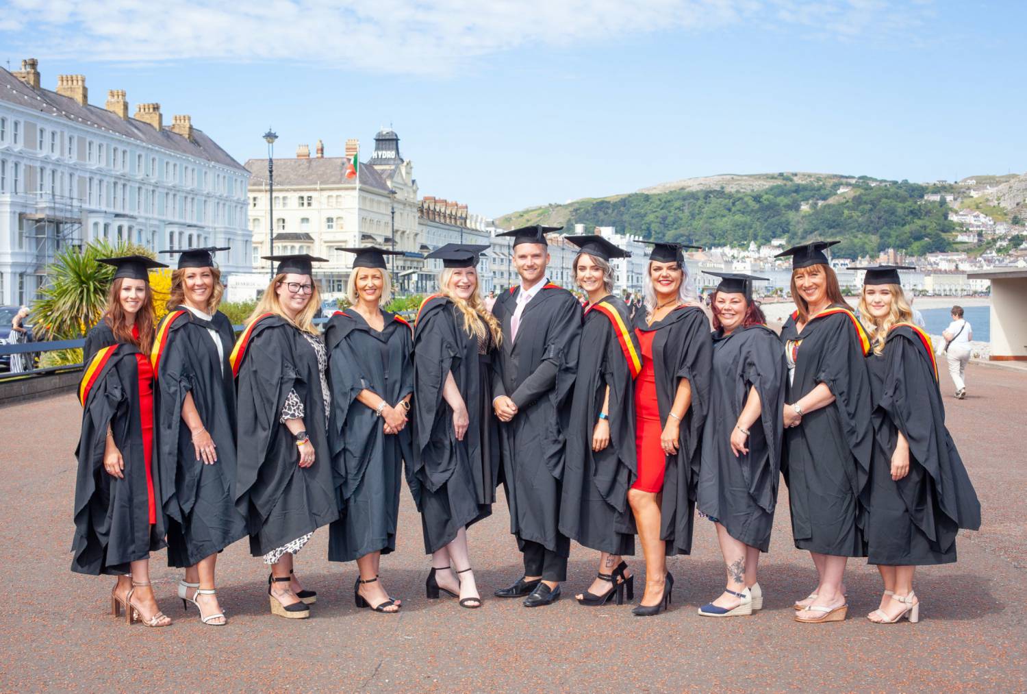 Myfyrwyr gradd yn dathlu ar ddiwrnod graddio