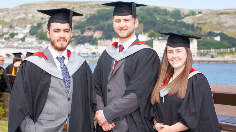 Three degree student celebrating on graduation day