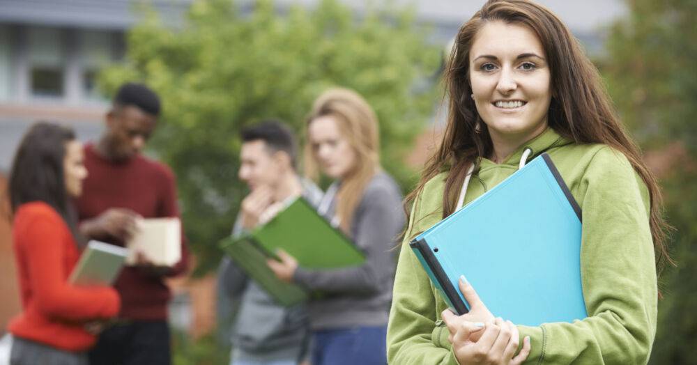 A group of learners with their work folders outside college