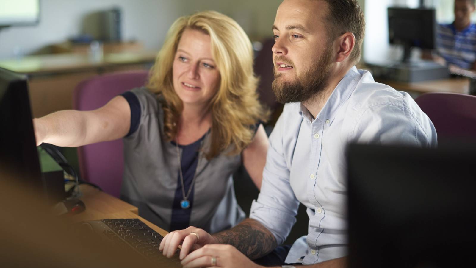 Two people using a computer