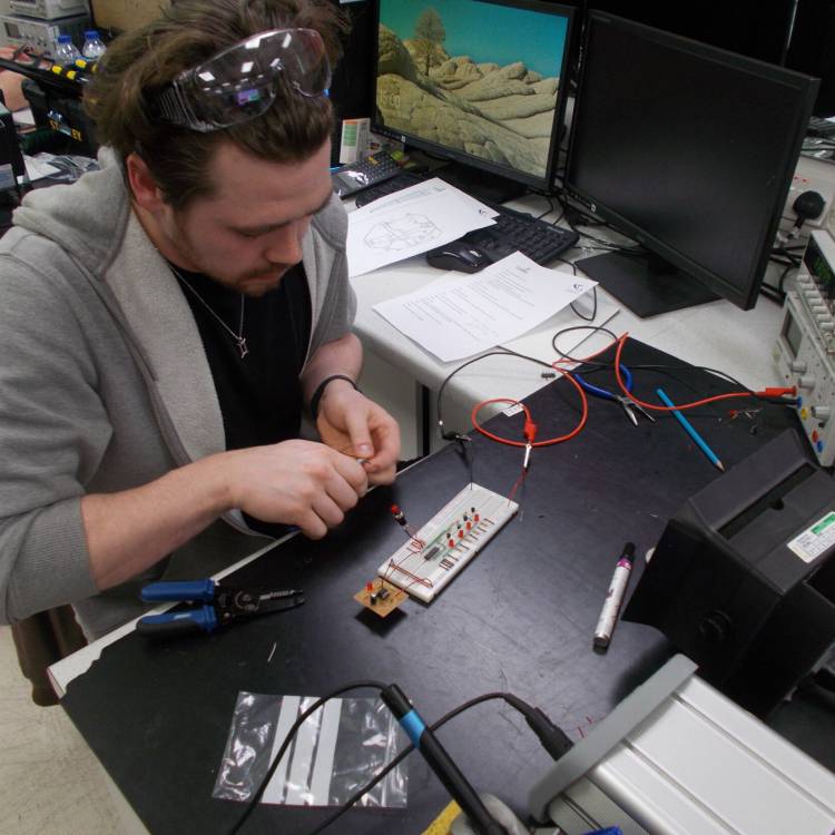 Adam Hopley ar waith fel rhan o'i Ddiploma Estynedig BTEC Lefel 3 mewn Peirianneg Drydanol