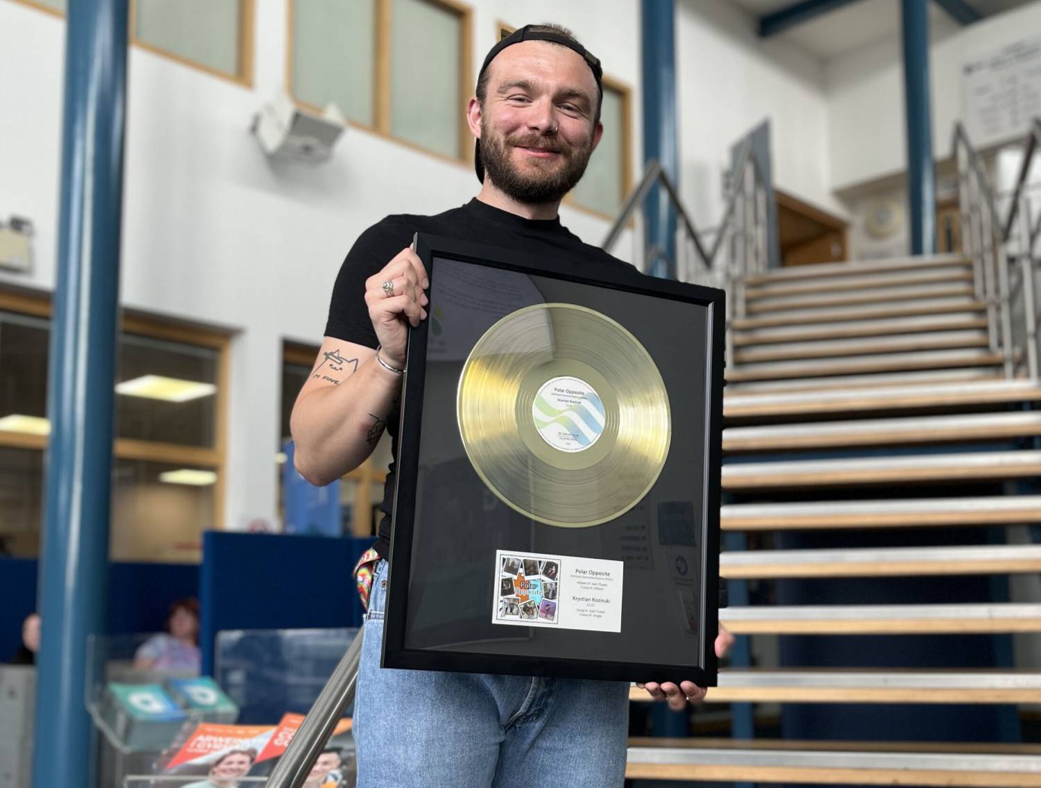 Past student Krystian Koziński with the gold disc presented to him at Coleg Llandrillo
