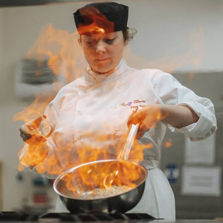 A student flambéing at the Orme View restaurant at Coleg Llandrillo’s Rhos campus