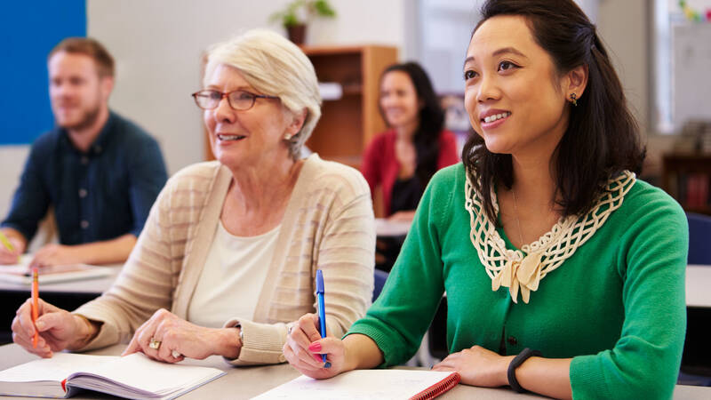 Part-time learners taking notes in a classroom