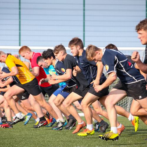 Chwaraewyr yn hyfforddi ar gae