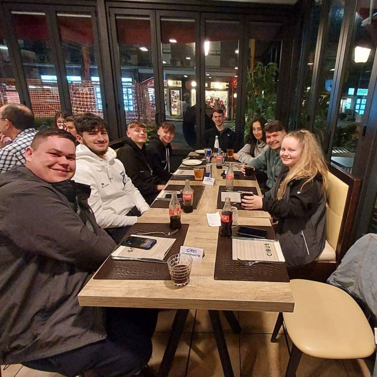 Myfyrwyr yn mwynhau pryd o fwyd yn ystod eu hymweliad ag ardal Twsgani, yr Eidal