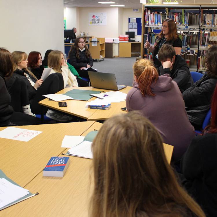 Myfyrwyr yn cymryd rhan mewn dadl yn llyfrgell Coleg Llandrillo ar gampws Llandrillo-yn-Rhos