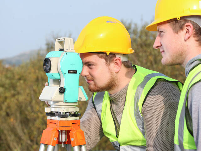 Students looking through a total station
