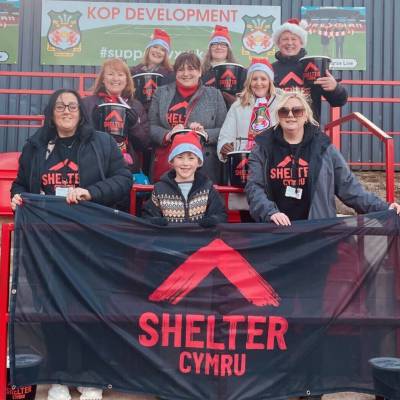 Gwirfoddolwyr Shelter Cymru y tu allan i'r Cae Ras yn Wrecsam