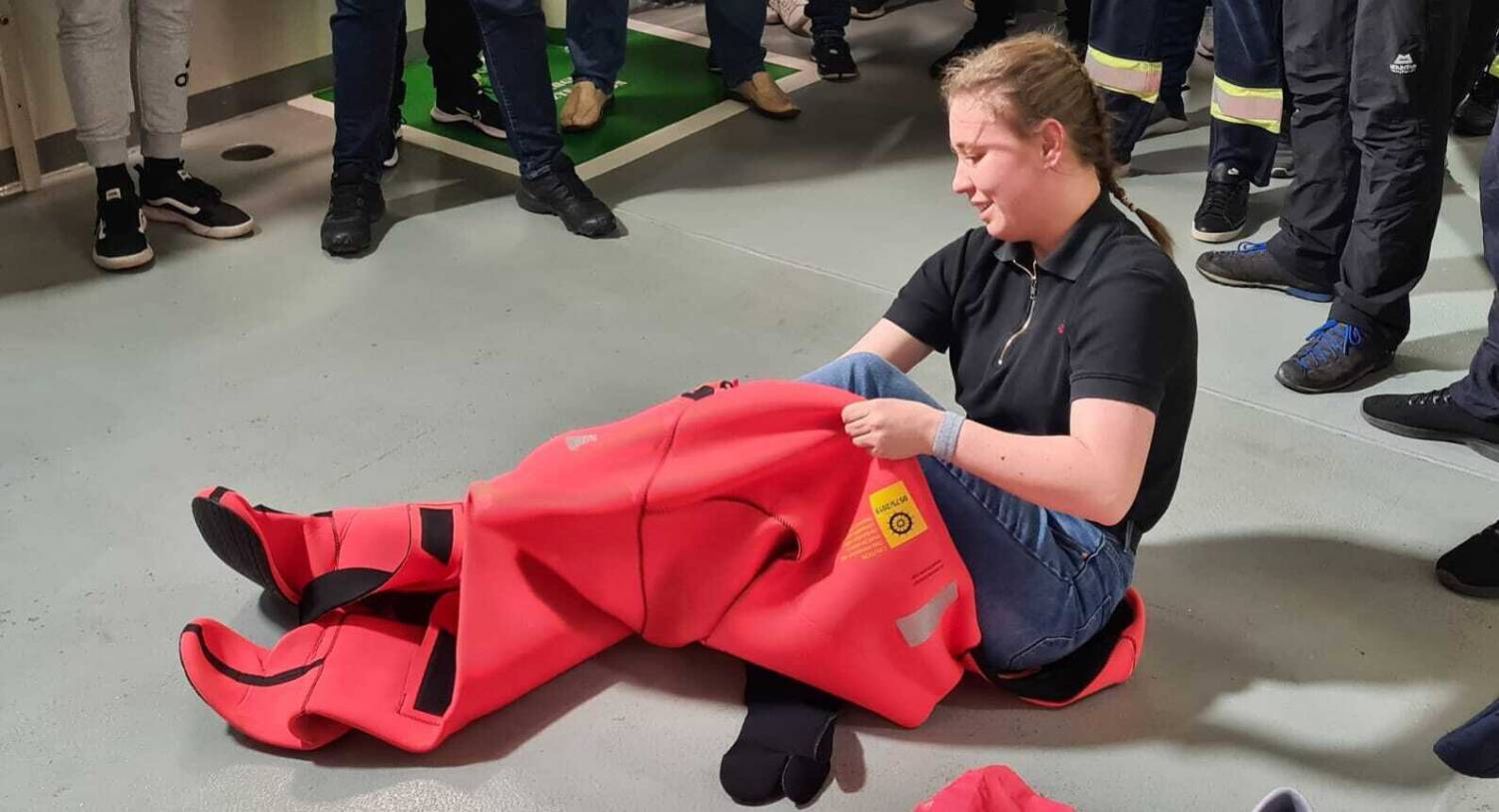 Former Coleg Menai student Stephanie putting on an immersion suit