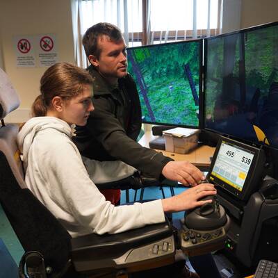 A student using a simulator at a Royal Forestry Society careers fair at Glynllifon