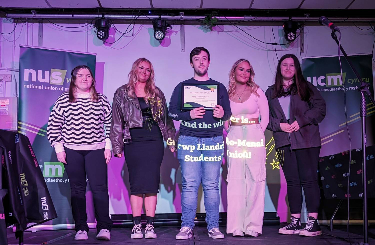 Grŵp Llandrillo Menai Student Union presidents on stage at the NUS Wales annual conference after winning the Learner Voice award