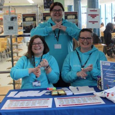 Staff signing at the Sign Language Week stall at Coleg Llandrillo