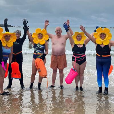 People on the beach at Trearddur Bay after enjoying a wild-water swim as part of a Multiply session