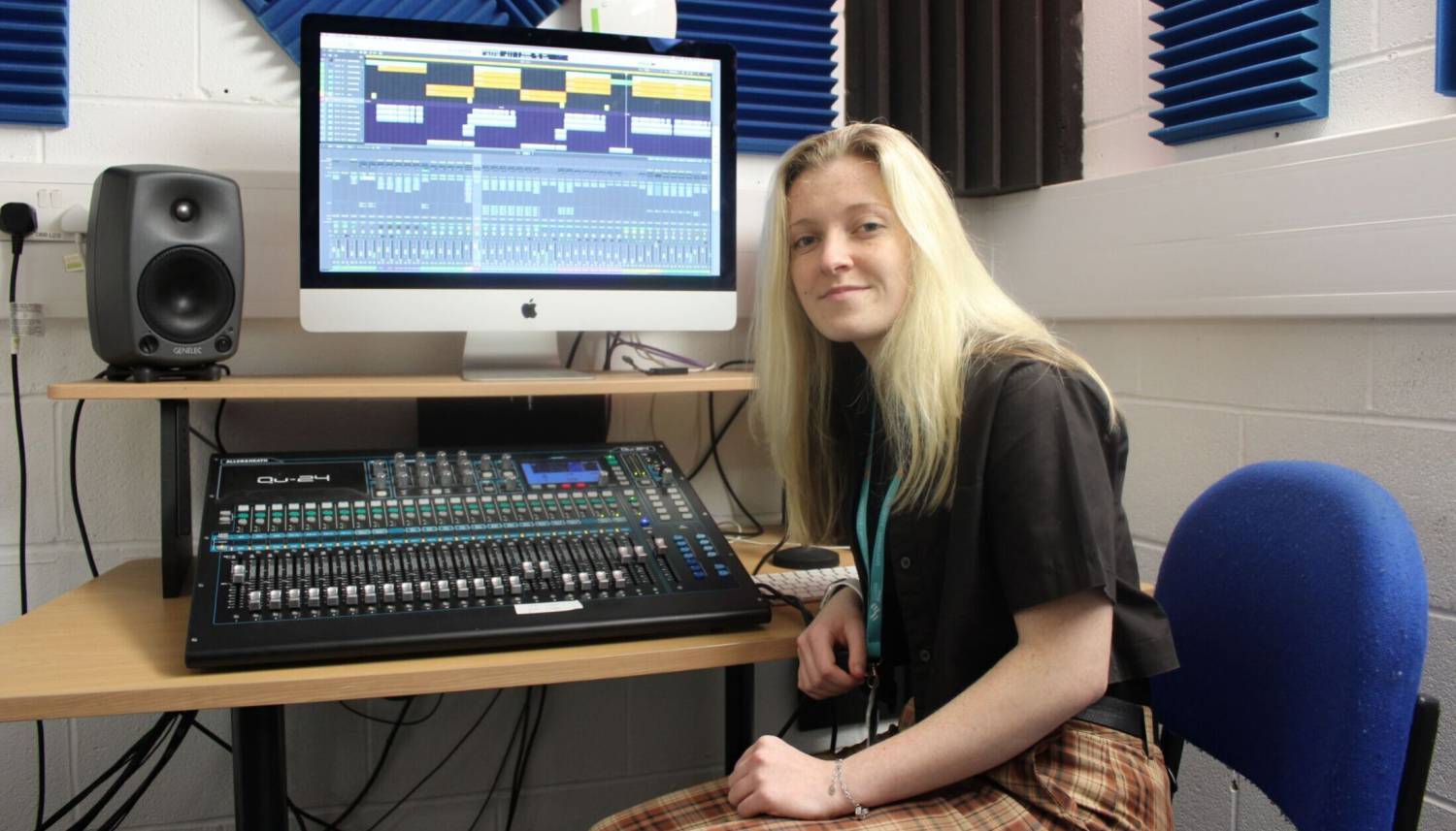 Hannah Popey at the mixing desk in a recording studio at Coleg Llandrillo