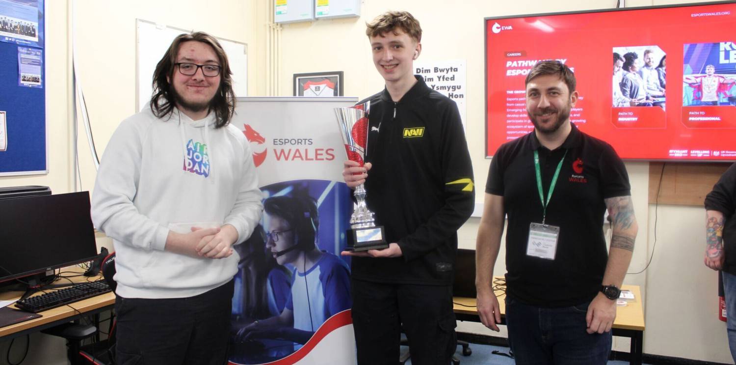 Luke Openshaw holding the Valorant Welsh Cup with fellow Coleg Llandrillo student Alfie Mitchell and Esports Wales CEO John Jackson