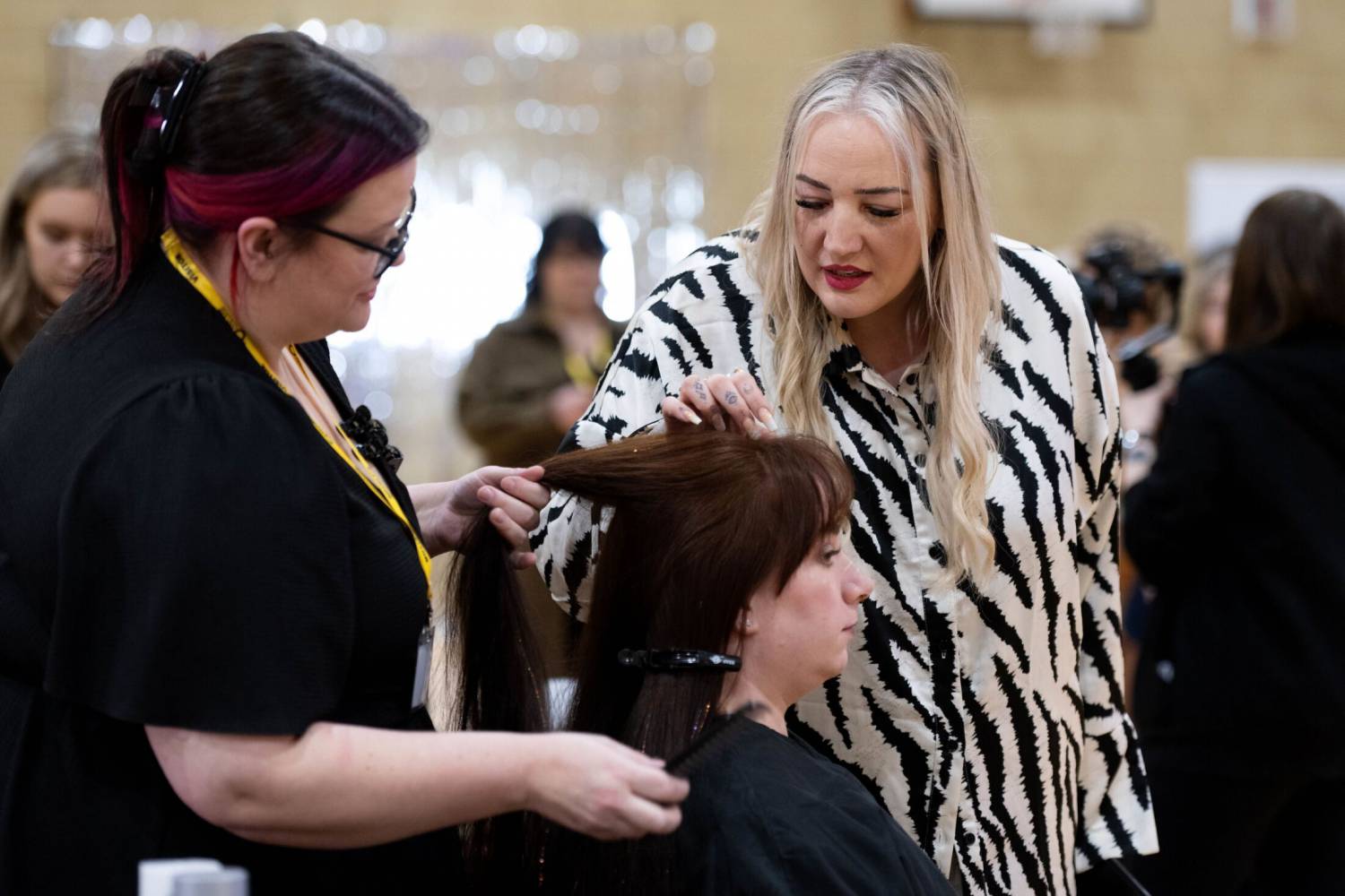Coleg Llandrillo student Ceri Thomas talking to judge Lisa Farrell while competing at the 2024 Concept Hair Learner of the Year final