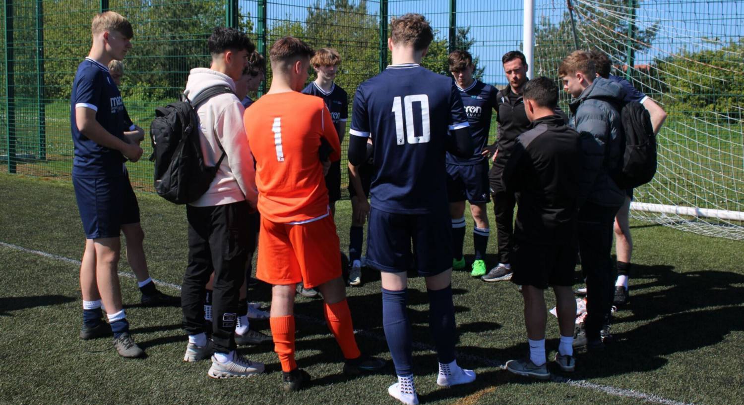 Coleg Llandrillo Football Academy team talking with coaches after winning the league title