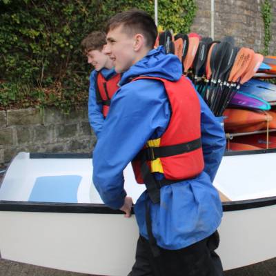 Students carrying a dinghy at The Conway Centre in Llanfairpwll