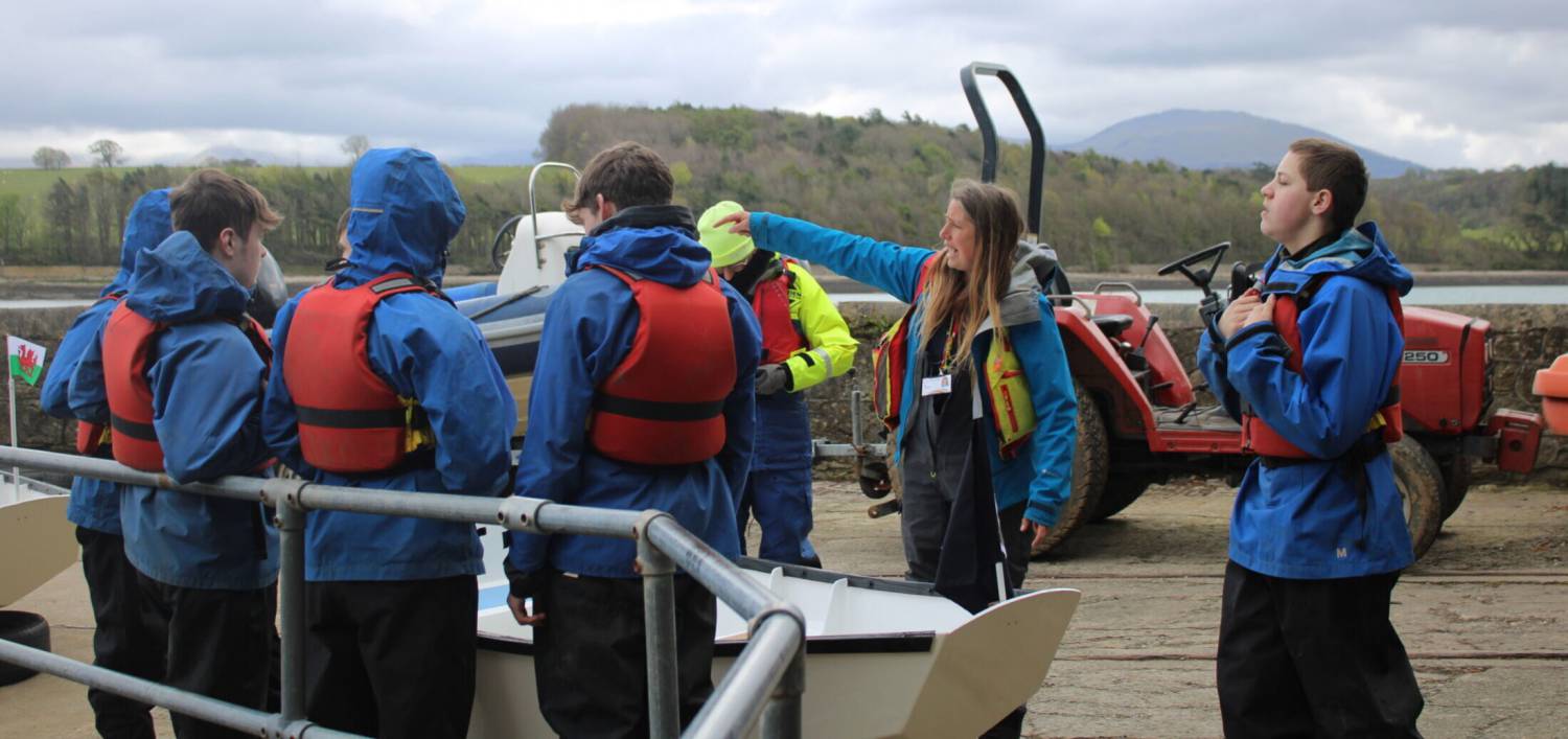 Myfyrwyr yn paratoi i lansio eu dingis ar y Fenai yng Nghanolfan Conwy yn Llanfairpwll