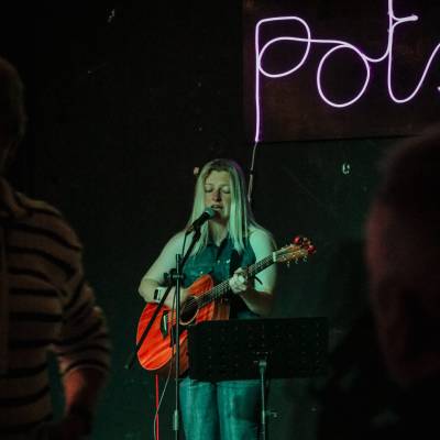 Hannah Popey yn perfformio yn ystod y gig yng Nghlwb Chwaraeon a Chymdeithasol Comrades Conwy