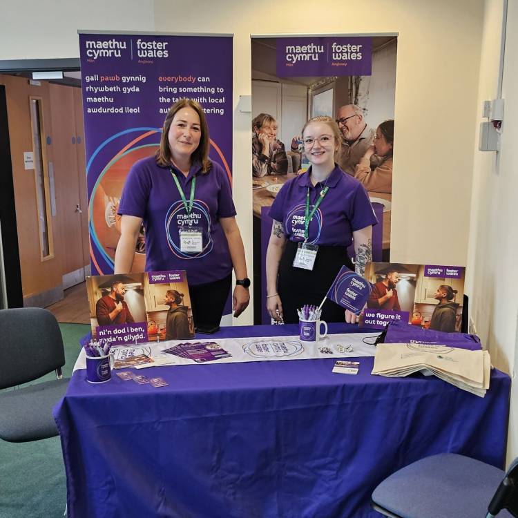 Staff Maethu Cymru yn cynnal stondin yn y dderbynfa ar gampws Coleg Menai yn Llangefni