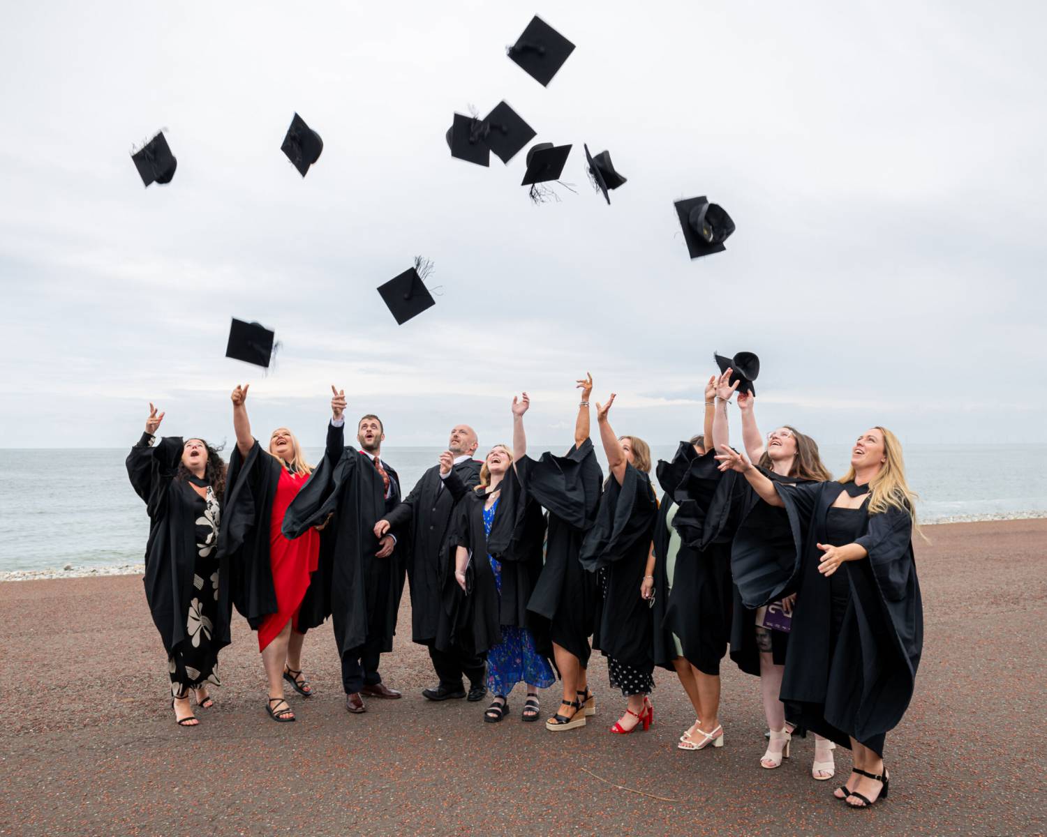 Myfyrwyr yn dathlu graddio ar y promenâd yn Llandudno