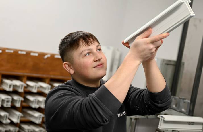 Owain Cunnington, cyn-fyfyriwr o Goleg Meirion-Dwyfor sy'n gweithio yn Rehau yn archwilio darn