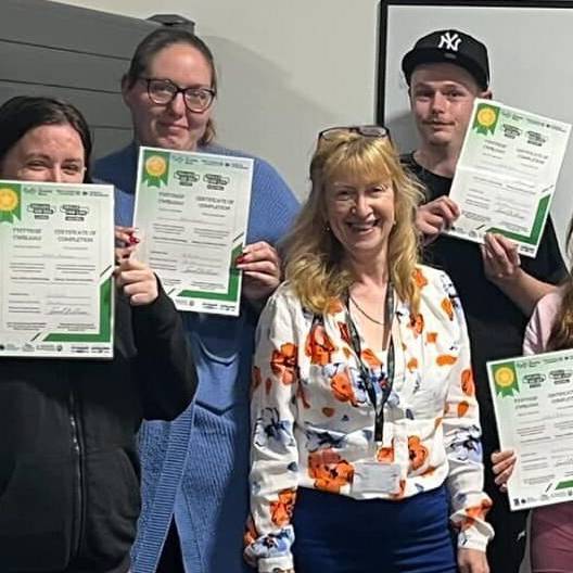 Y tiwtor Samantha Hunt (canol), a’r dysgwyr gyda’u tystysgrifau ar ôl cwblhau cwrs Lluosi yn Blossom & Bloom yn y Rhyl