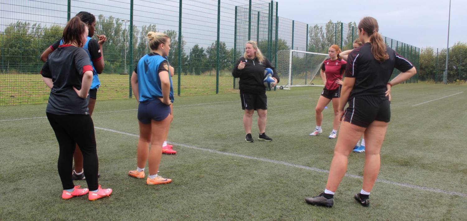 Assistant coach Lucy Brown talking to rugby academy students on the 3G pitch at Coleg Llandrillo in Rhos-on-Sea