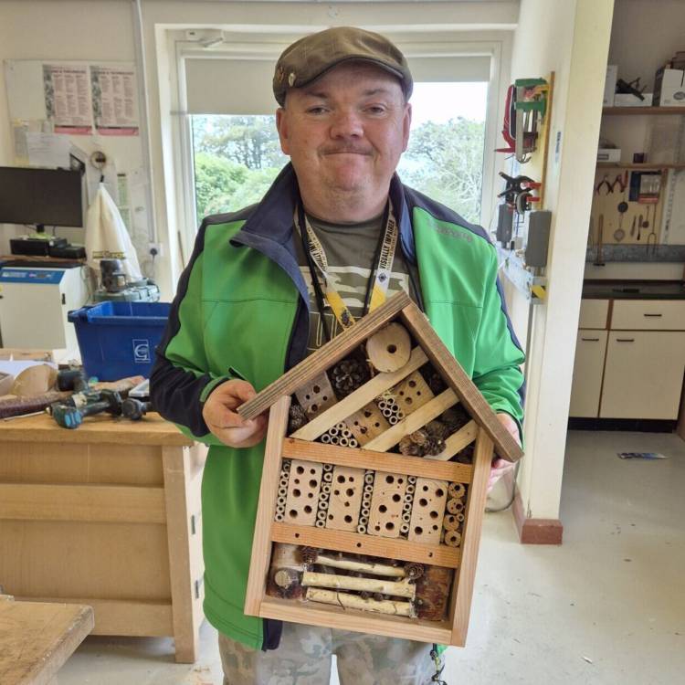 Paul Jenkinson, dysgwr ar y rhaglen Lluosi, gyda thŷ chwilod a adeiladodd ar gwrs Sgiliau Gwaith Coed a Rhifedd Ymarferol