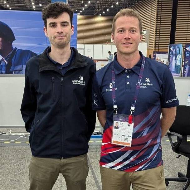 Bryn Jones, darlithydd yng Ngholeg Menai, gyda chystadleuydd Oscar McNaughton yn Lyon ar gyfer WorldSkills 2024