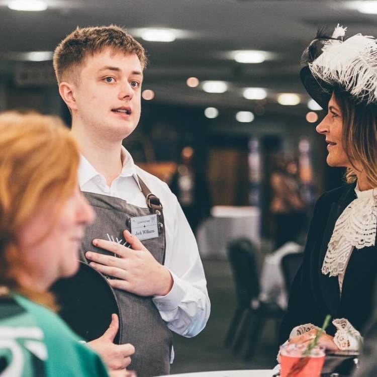 Former Coleg Meirion-Dwyfor student Jack Williams talking to guests while competing at the Young Waiter 2024 Welsh final