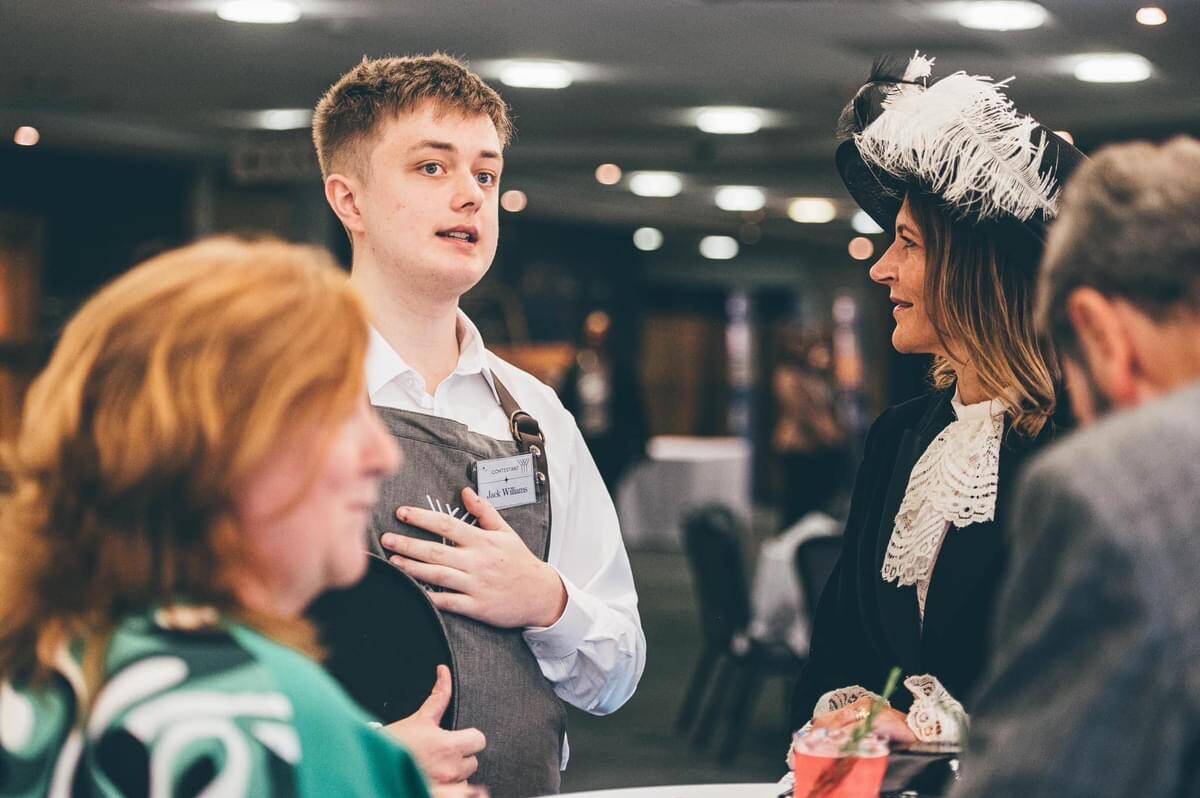 Former Coleg Meirion-Dwyfor student Jack Williams talking to guests while competing at the Young Waiter 2024 Welsh final