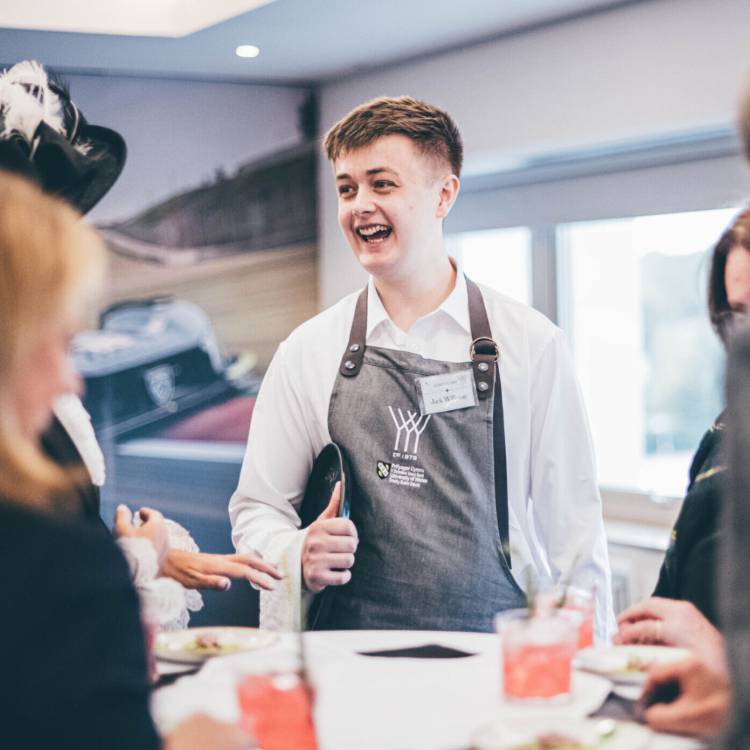 Former Coleg Meirion-Dwyfor student Jack Williams talking to guests while competing at the Young Waiter 2024 Welsh final