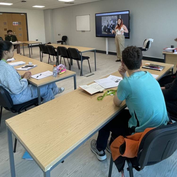 Y Farwnes Carmen Smith yn siarad â myfyrwyr ar gampws newydd Coleg Menai yn Nhŷ Menai