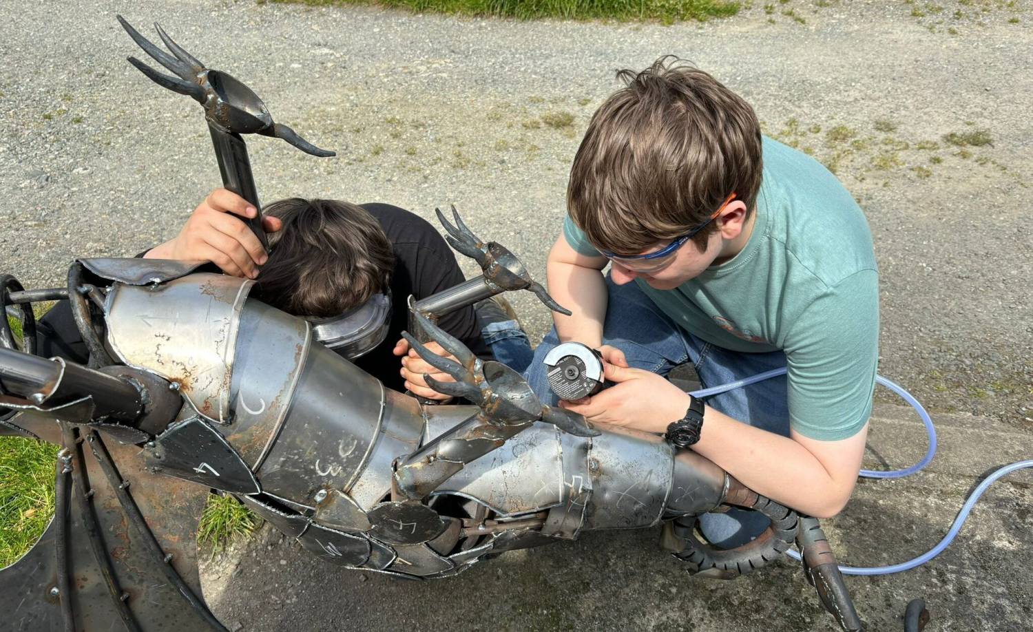 Coleg Menai students Harry Vanmaele (left) and Dai Ifor Evans-Jones working on a steel dragon