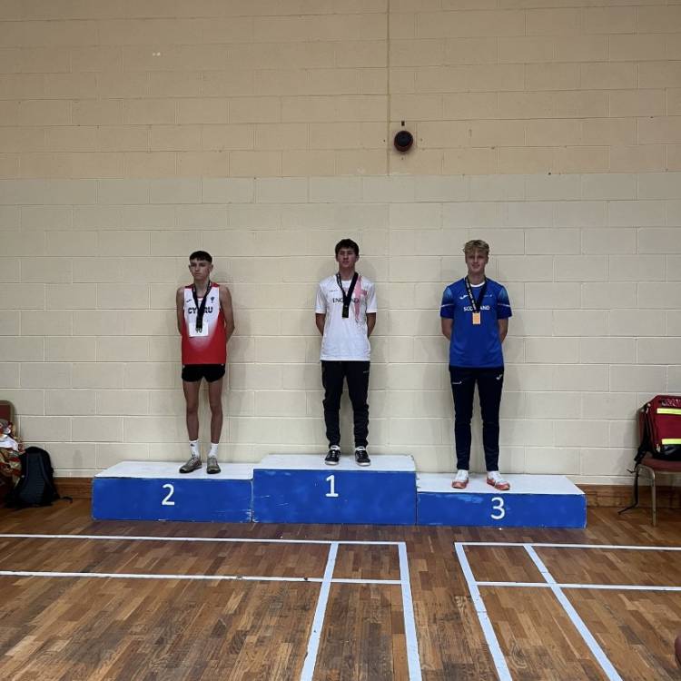 Noa Vaughan a chyd-enillwyr medalau ar y podiwm ar ôl Pencampwriaethau Rhedeg Mynydd Iau Prydain ac Iwerddon