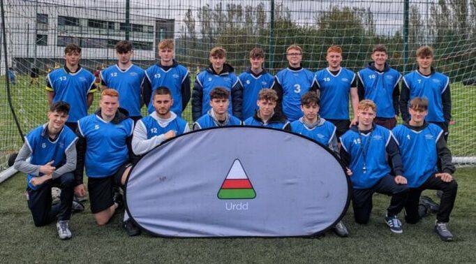 Coleg Llandrillo sport students with the Urdd flag on the 3G pitch at Coleg Llandrillo’s Rhos-on-Sea campus