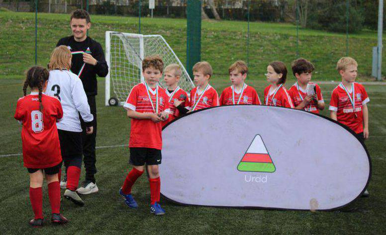 Ysgol Bod Alaw’s team collecting their medals after finishing second in the Urdd Conwy Year 3 and 4 mixed football tournament