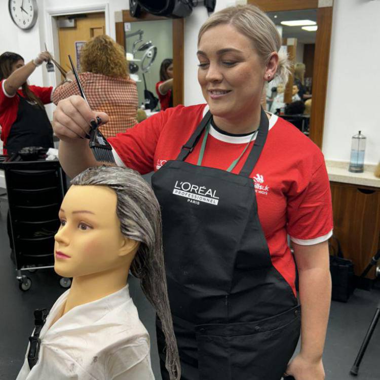 Heather Wynne, myfyrwraig o Goleg Llandrillo, yn steilio gwallt yn rownd derfynol WorldSkills UK 2024