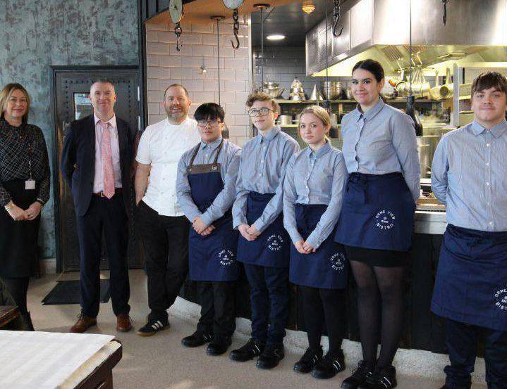 Bryn Williams with Coleg Llandrillo Assistant Principal Samantha McIlvogue, Principal Paul Flanagan and hospitality students at Porth Eirias