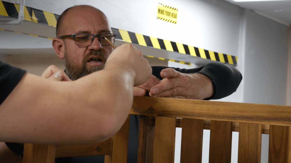 Dysgwr yn ystod dosbarth Lluosi ar adeiladu meinciau yn siop Happitat Crest Cooperative yn Llandudno