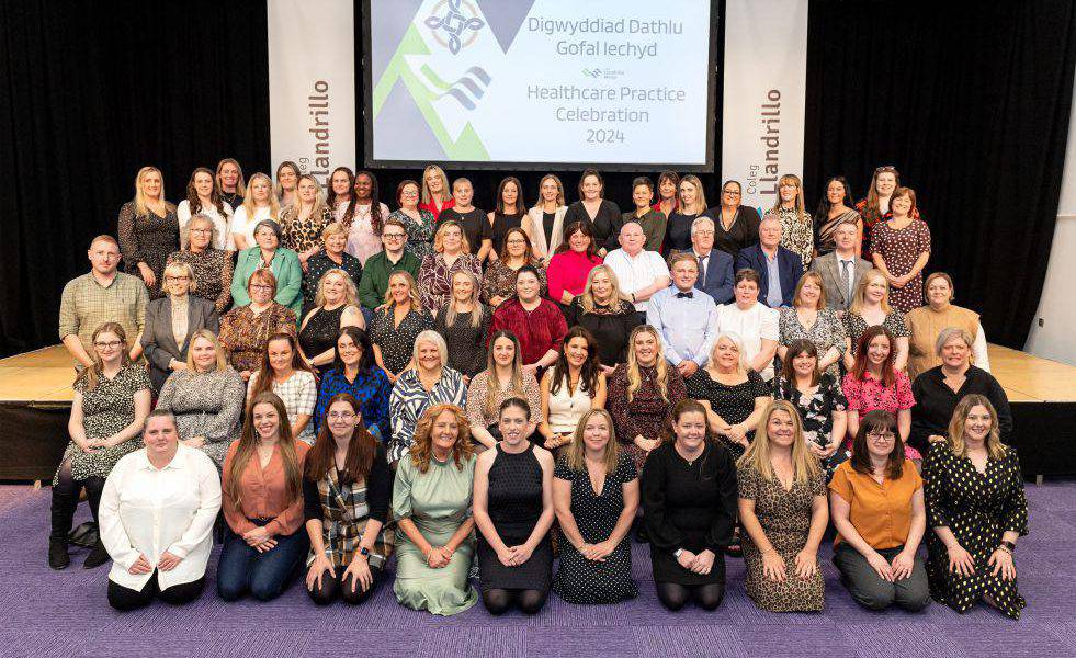 Dysgwyr mewn seremoni i ddathlu cyflawni ⁠Tystysgrif Addysg Uwch Lefel 4 mewn Ymarfer Gofal Iechyd
