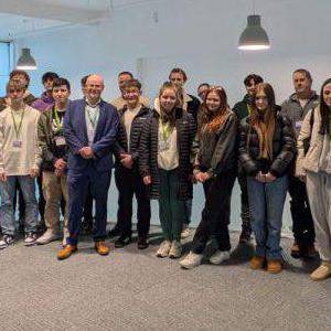 Dirprwy Asiant Cymru Banc Lloegr, Ian Derrick a Phennaeth Coleg Menai, Dr Siôn Peters-Flynn gyda myfyrwyr ar gampws Bangor