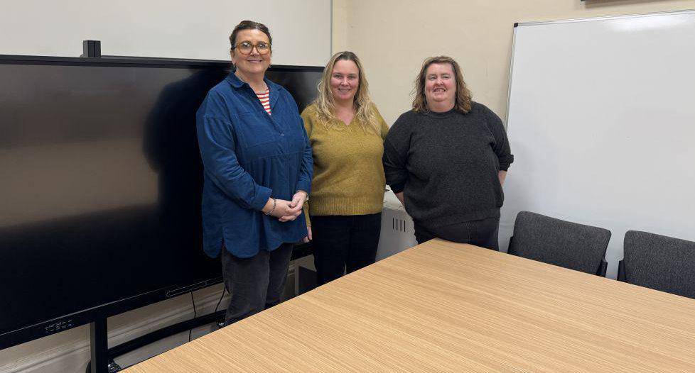 Staff o Age Cymru Bontnewydd gyda’r sgrin deledu a ddarparwyd gan Lluosi