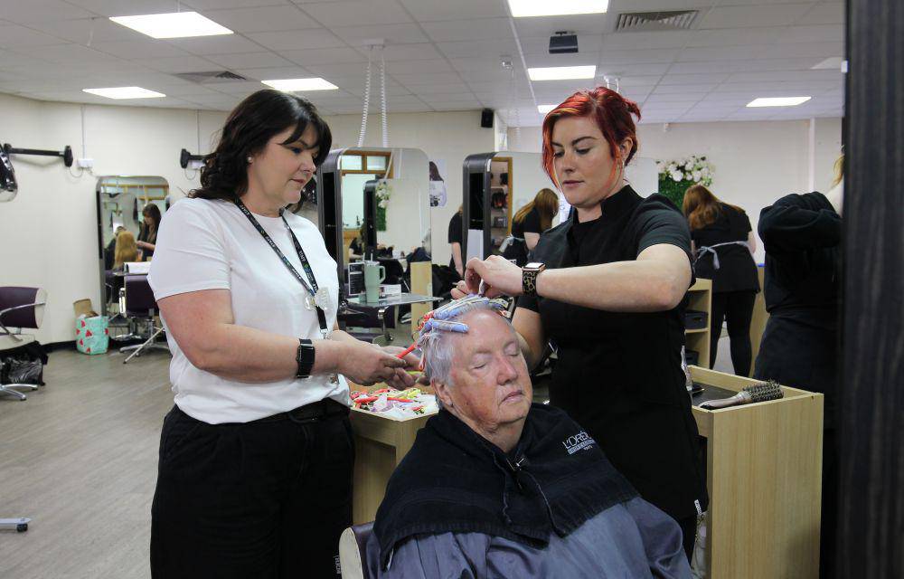 Michelle Jones (left) supervising a student styling a customer’s hair in the salon at Coleg Llandrillo’s Rhos-on-Sea campus